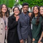A group of diverse colleagues smiling together, showcasing teamwork and friendship outdoors.